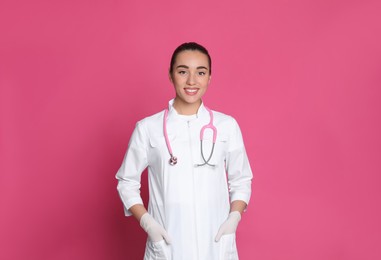Photo of Portrait of beautiful young doctor on pink background
