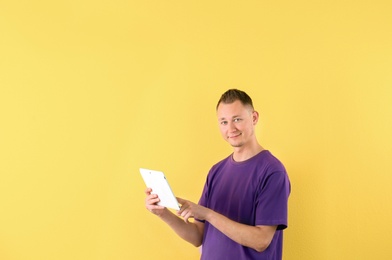 Photo of Portrait of handsome man with tablet on color background