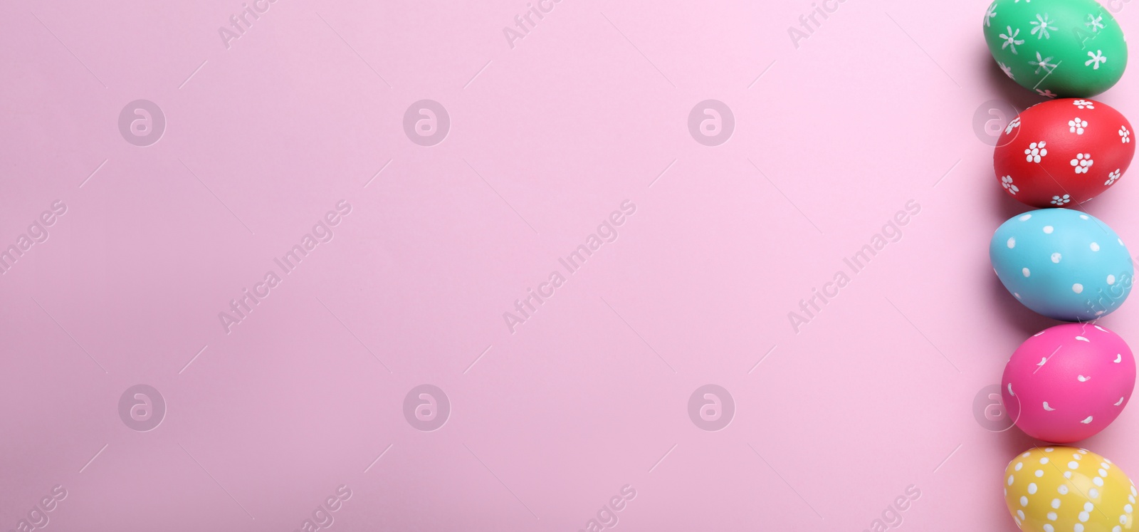 Photo of Bright painted eggs on pink background, flat lay with space for text. Happy Easter