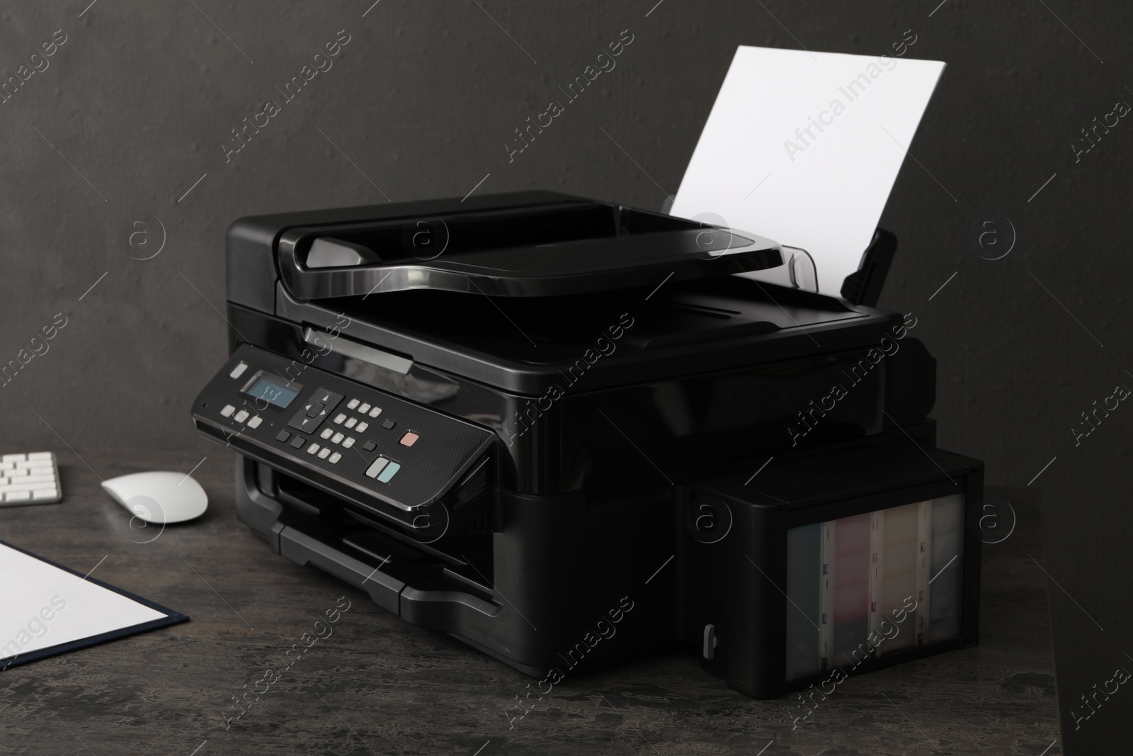 Photo of Modern printer with paper on grey table at workplace