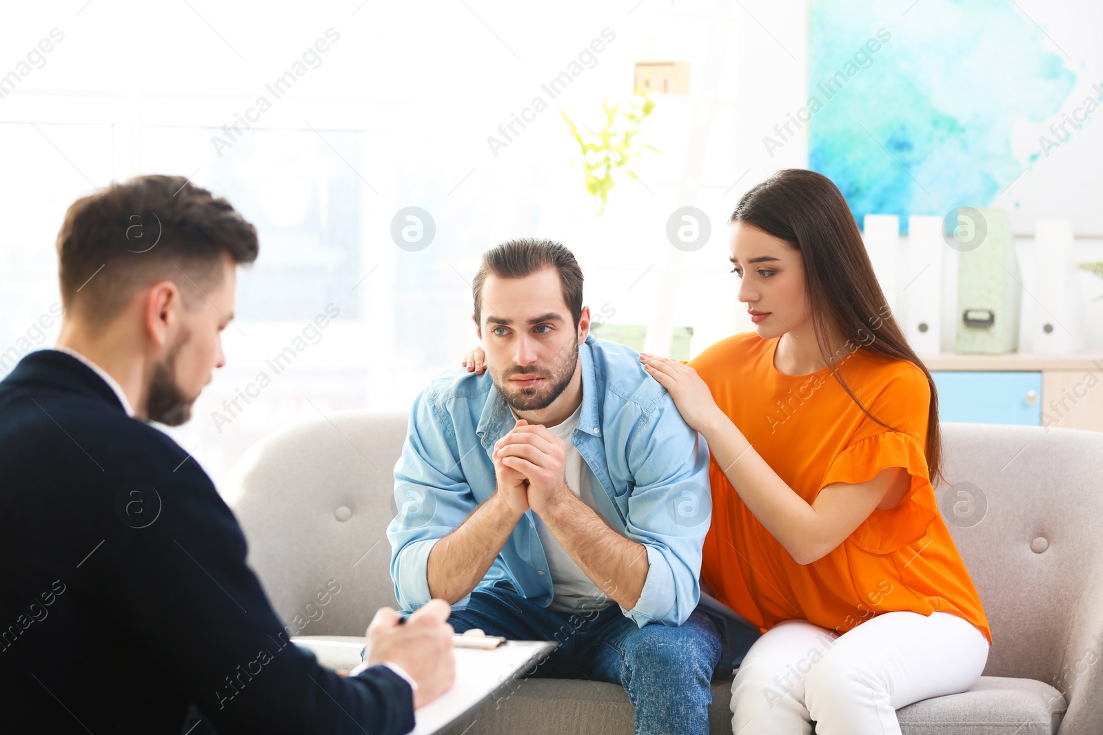 Photo of Family psychologist working with young couple in office