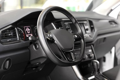 Photo of View of steering wheel and dashboard inside of modern car