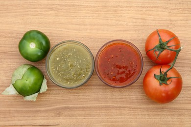 Photo of Tasty salsa sauces and different tomatoes on wooden table, flat lay
