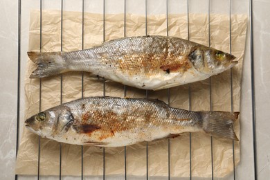 Baked fish on light marble table, top view