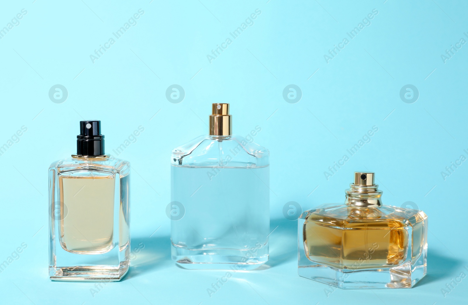 Photo of Bottles of perfume on color background