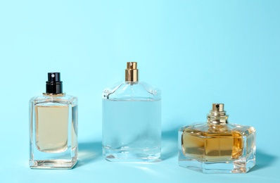 Bottles of perfume on color background