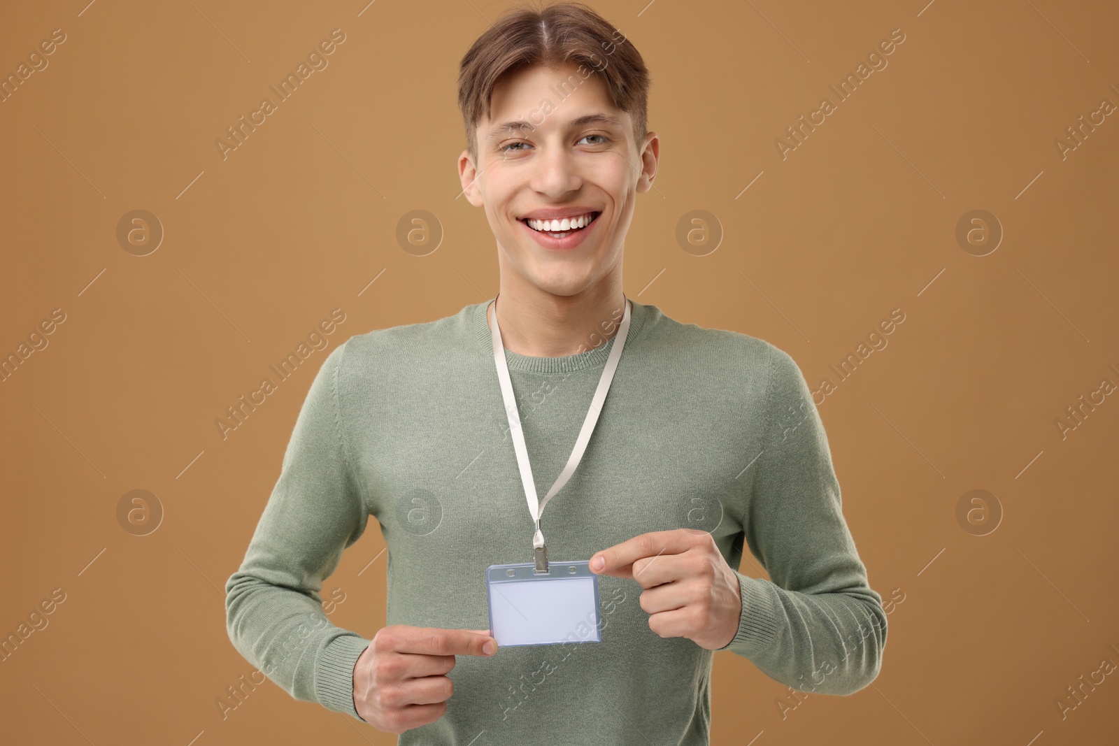 Photo of Happy man with blank badge on light brown background