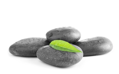 Photo of Spa stones and green leaf with water drops on white background