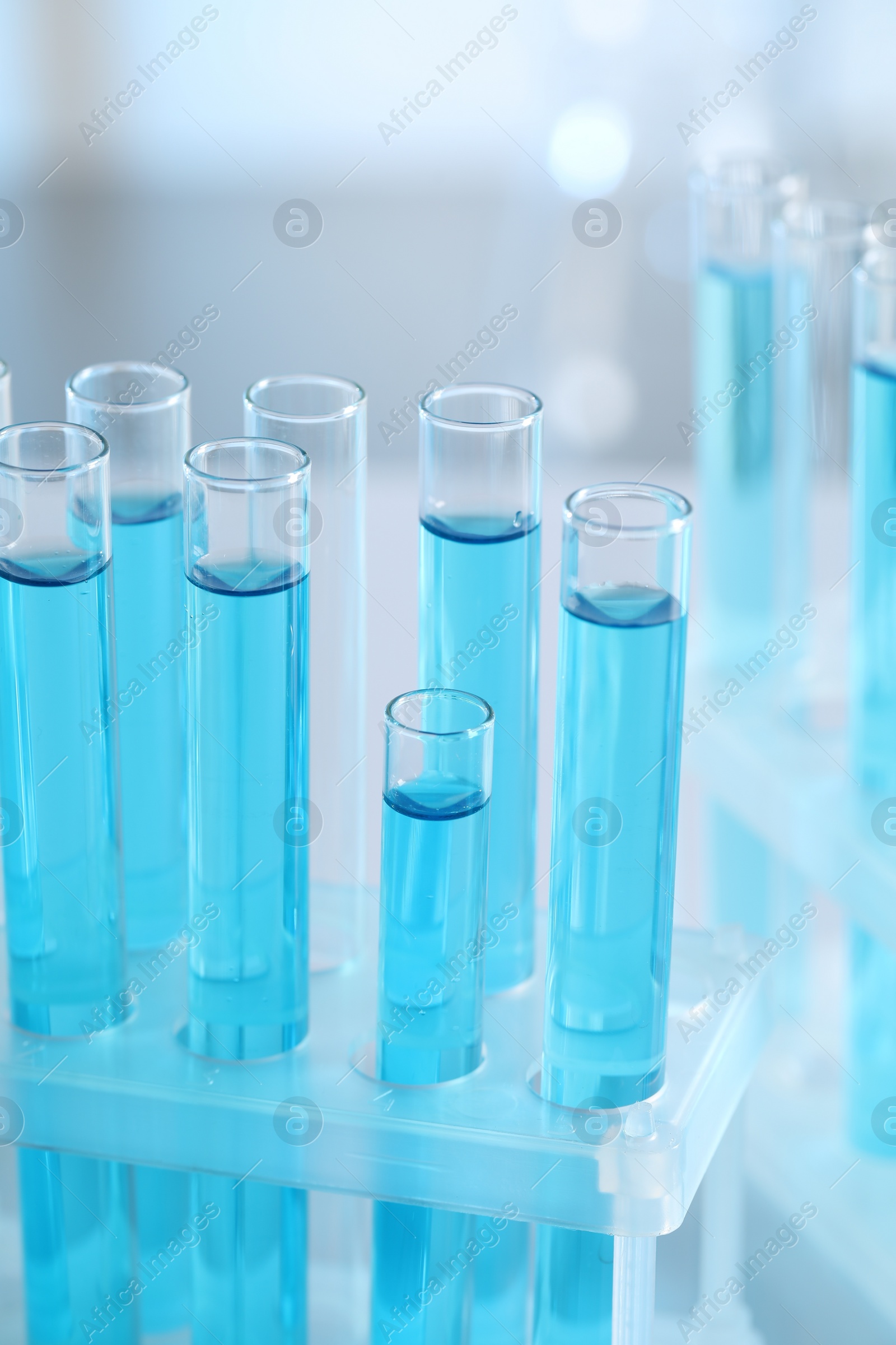 Photo of Test tubes with light blue liquid in laboratory, closeup