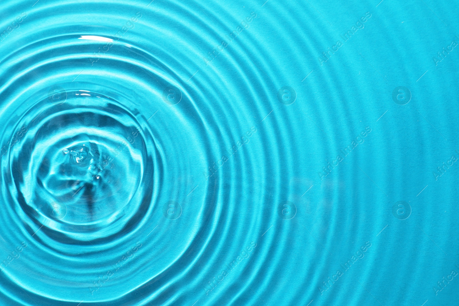 Image of Rippled surface of clear water on light blue background, top view