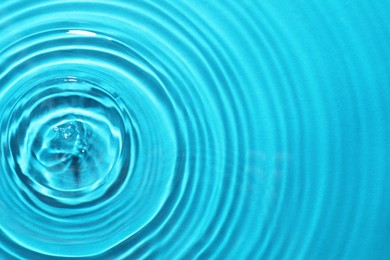 Rippled surface of clear water on light blue background, top view