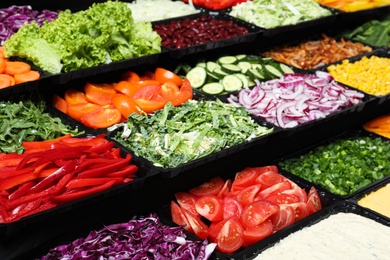 Salad bar with different fresh ingredients as background