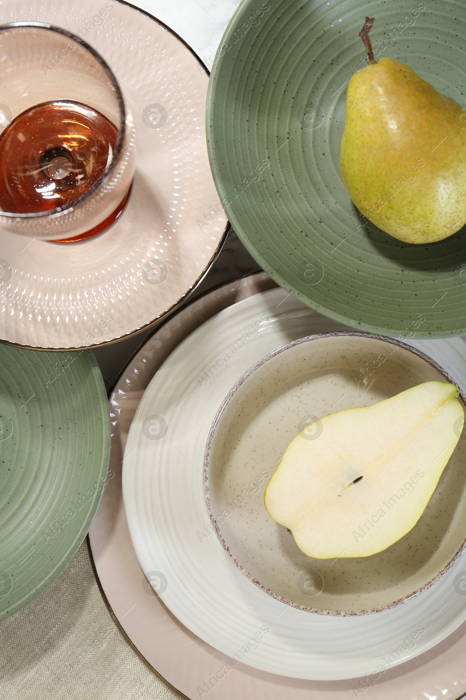 Photo of Stylish ceramic plates, glass and pears on table, flat lay