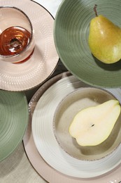 Photo of Stylish ceramic plates, glass and pears on table, flat lay