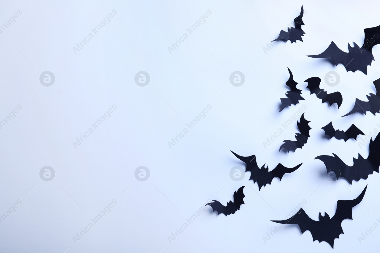 Photo of Many black paper bats on white background, flat lay with space for text. Halloween decor