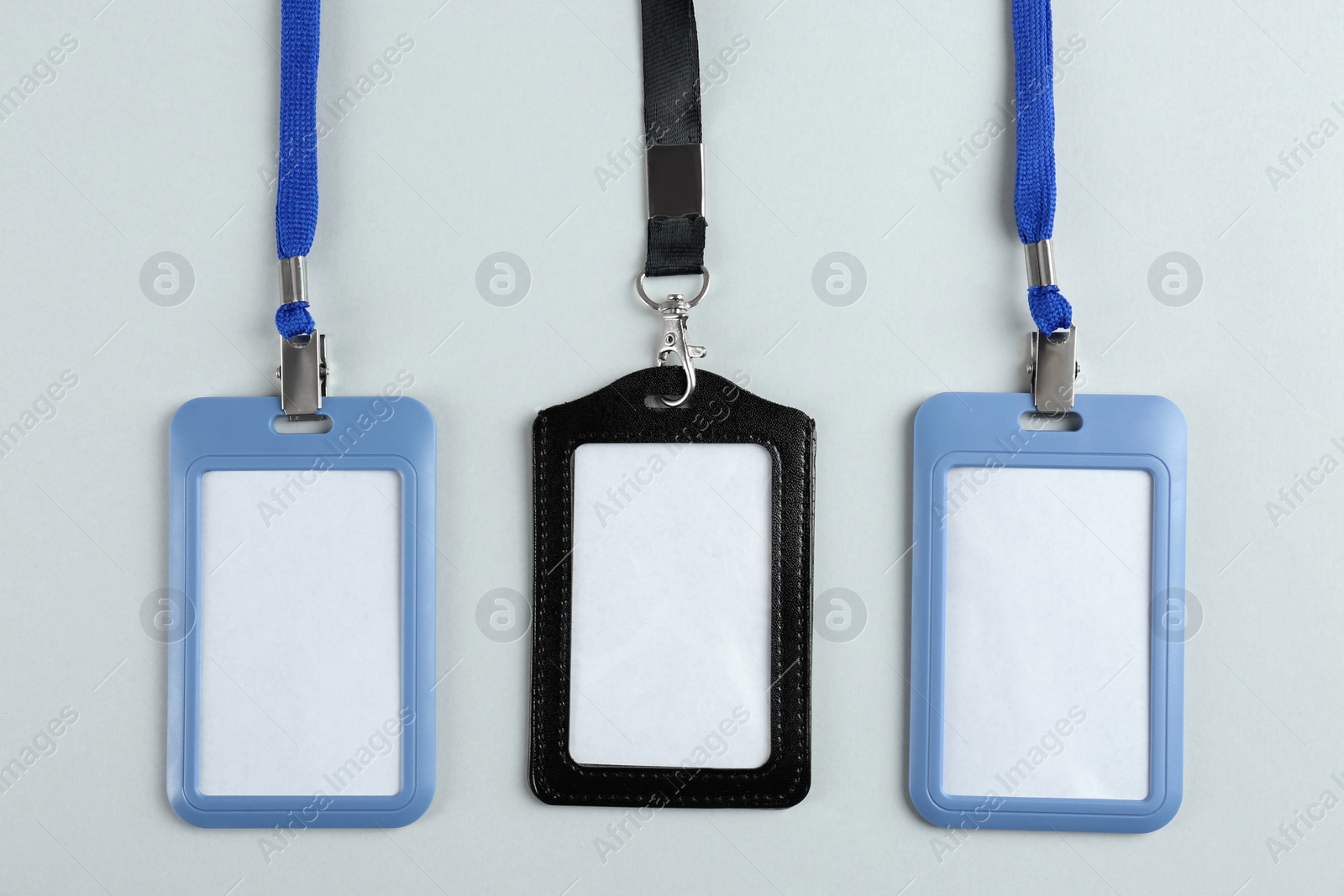 Photo of Blank badges on light background, flat lay. Mockup for design