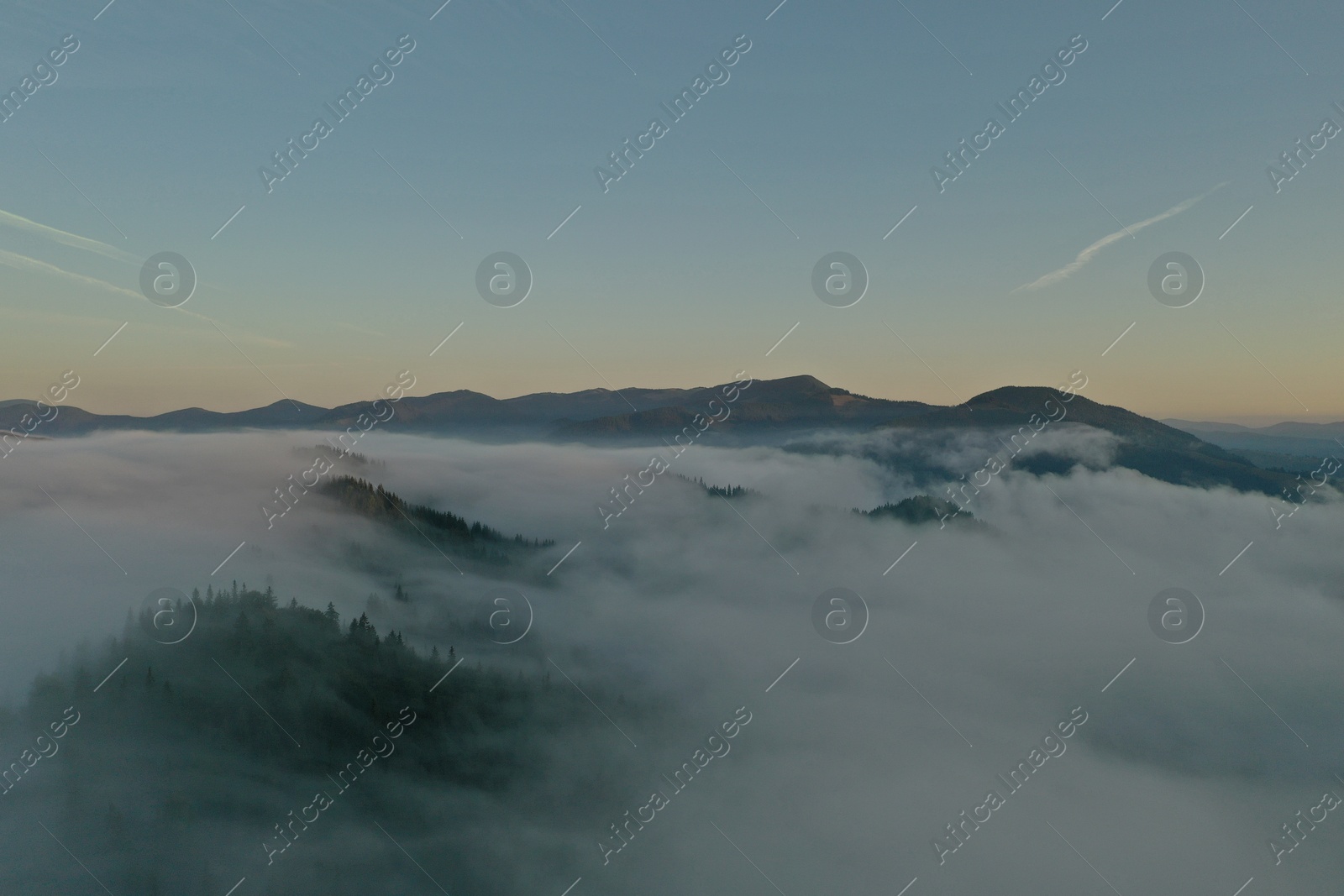 Photo of Aerial view of beautiful mountains covered with fluffy clouds in morning