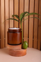Photo of Jar of natural cream with olive essential oil on wooden background