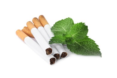 Menthol cigarettes and fresh mint leaves on white background