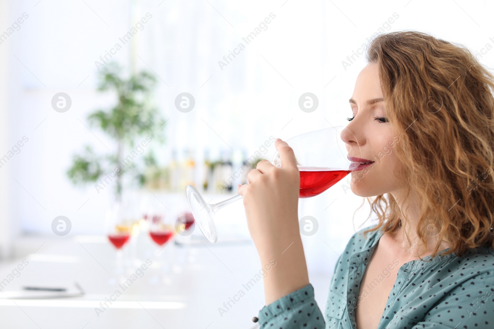 Photo of Woman with glass of delicious wine indoors