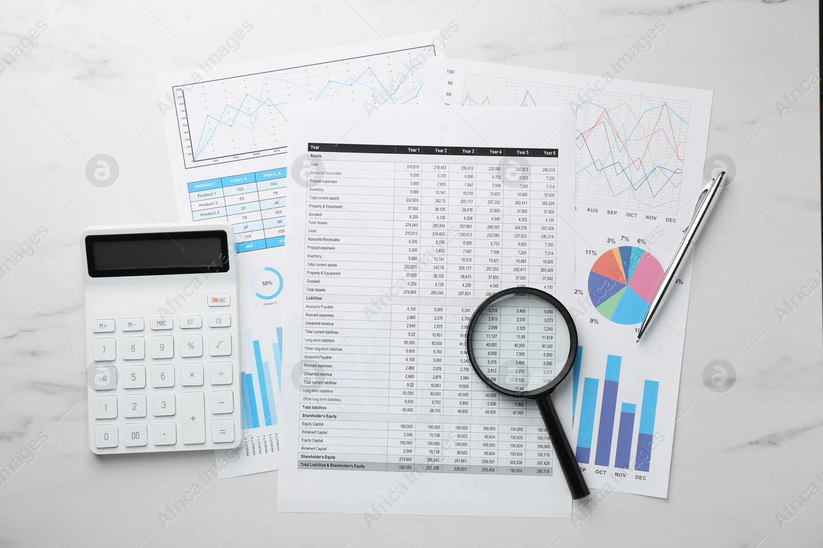 Photo of Accounting documents, calculator, magnifying glass and pen on white marble table, top view