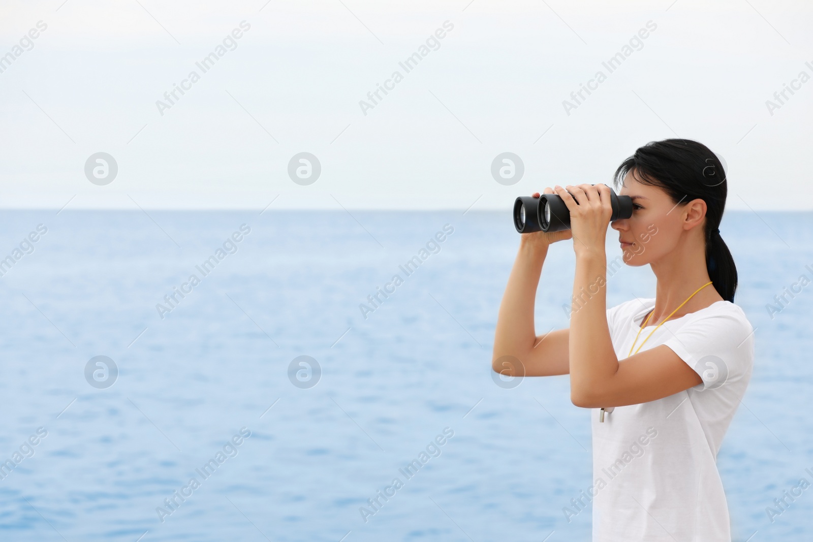 Photo of Beautiful female lifeguard with binocular near sea