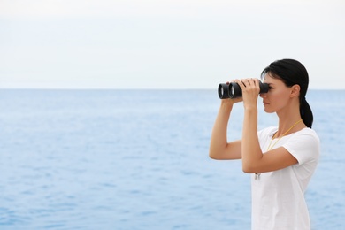 Beautiful female lifeguard with binocular near sea