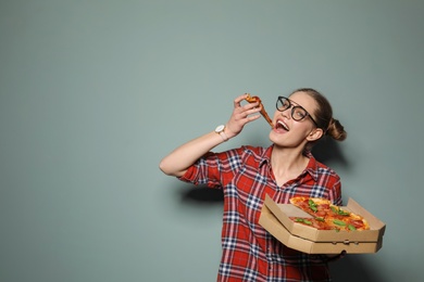 Attractive young woman with delicious pizza on color background