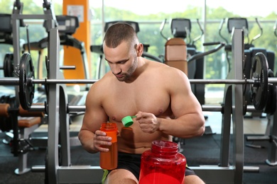 Photo of Portrait of athletic man preparing protein shake in gym
