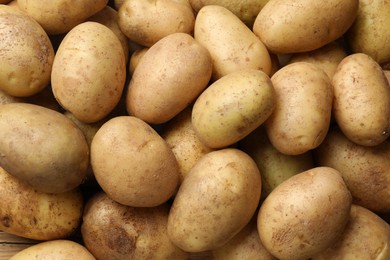 Photo of Fresh raw potatoes as background, top view