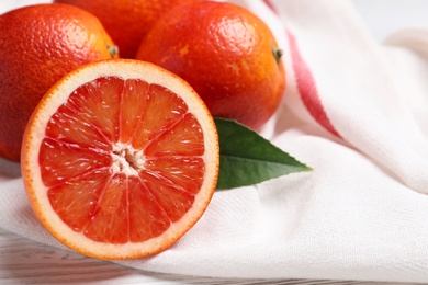 Photo of Whole and cut red oranges on white wooden table, closeup