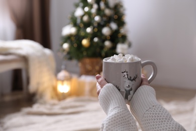 Woman with delicious hot drink at home, closeup. Space for text