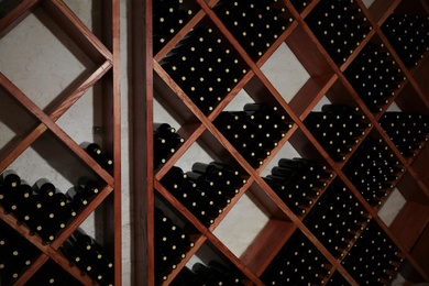 Photo of Many bottles of wine on shelves in cellar
