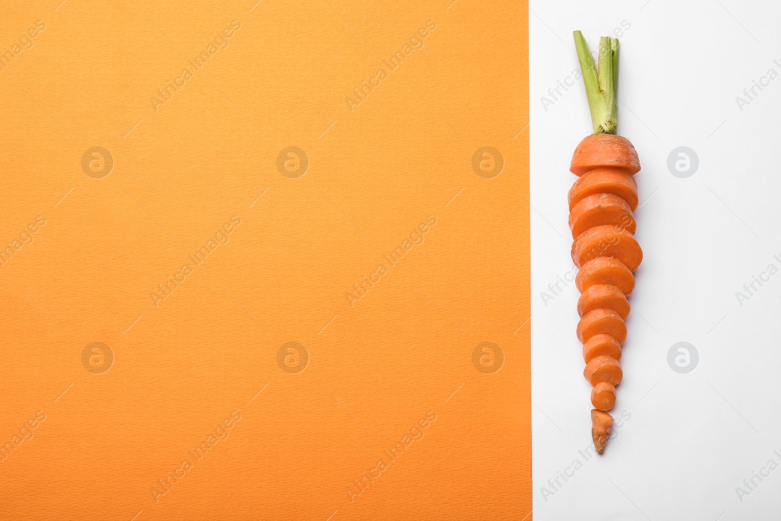 Photo of Fresh sliced carrot and space for text on color background, top view