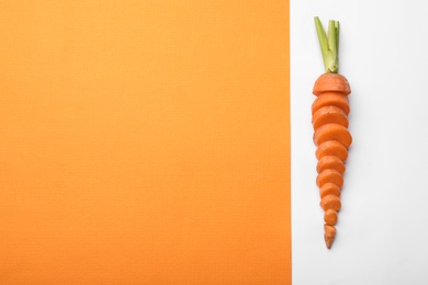 Photo of Fresh sliced carrot and space for text on color background, top view