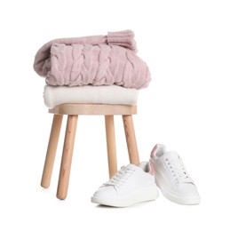 Stool with stylish clothes and shoes on white background