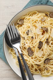 Tasty spaghetti with truffle on wooden table, top view