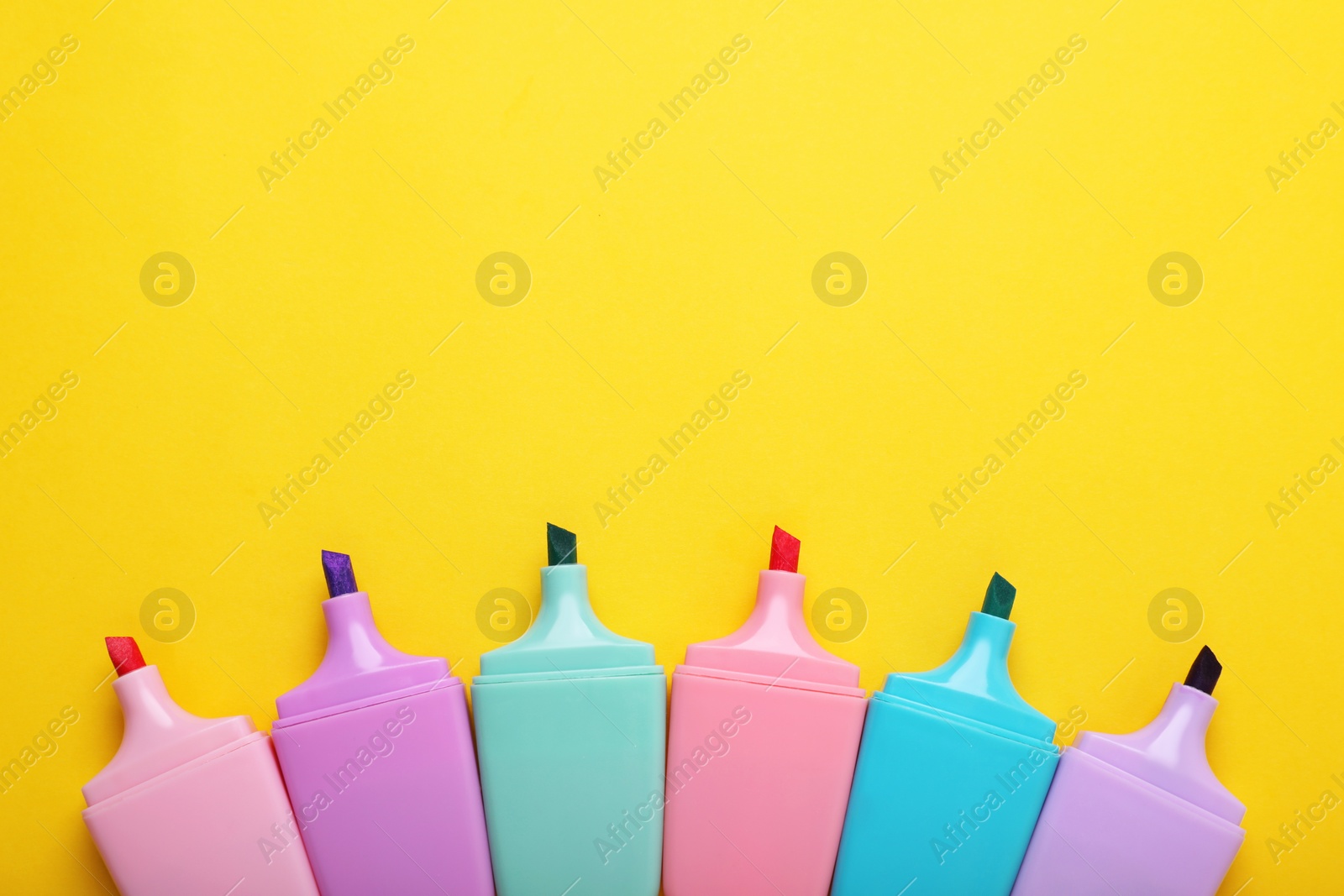 Photo of Many colorful markers on yellow background, flat lay. Space for text