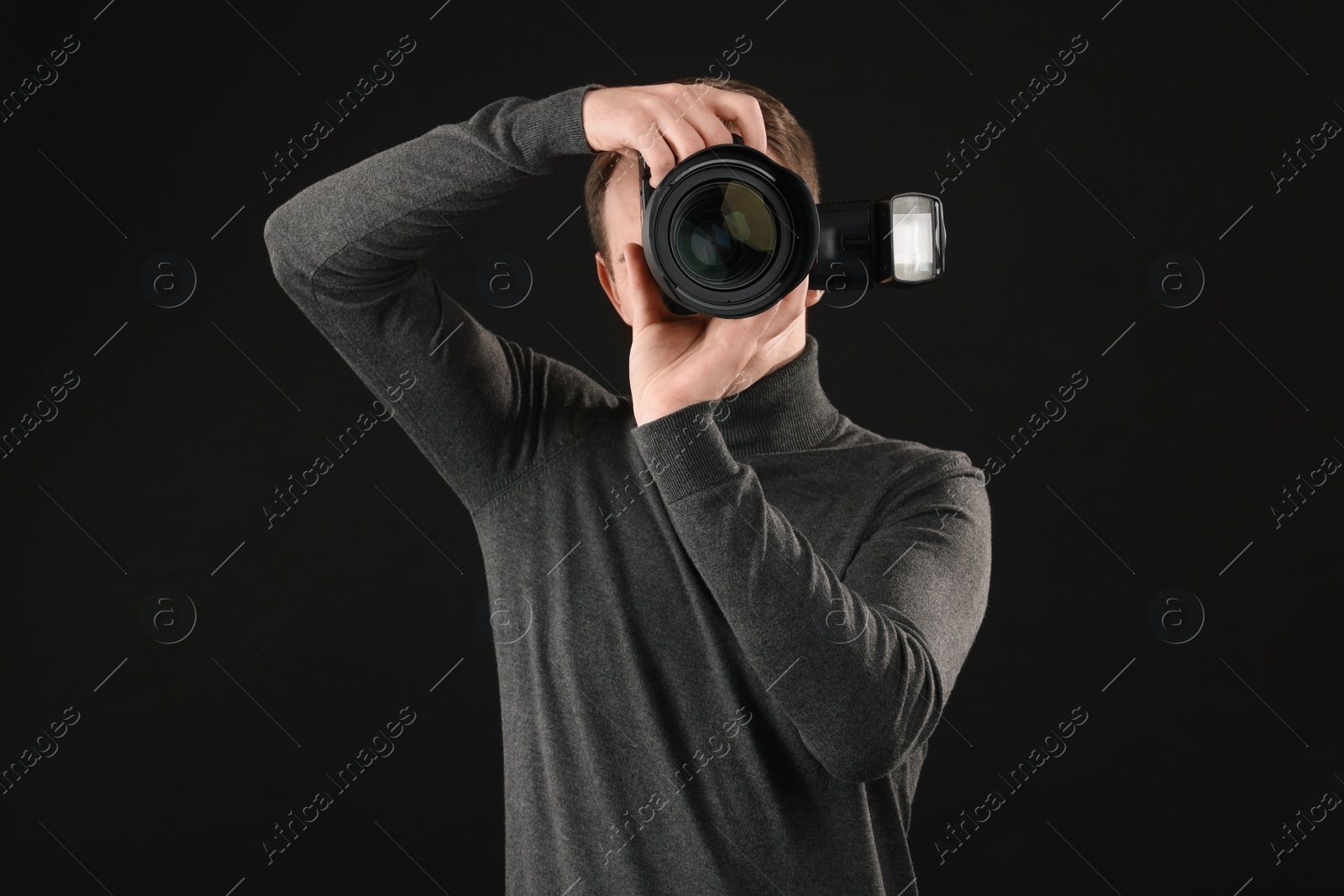 Photo of Professional photographer taking picture on black background