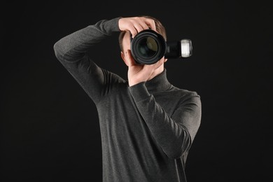 Professional photographer taking picture on black background