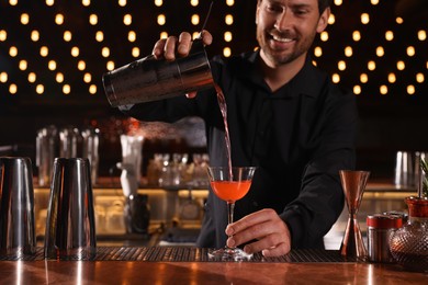 Photo of Bartender preparing fresh alcoholic cocktail in bar, selective focus