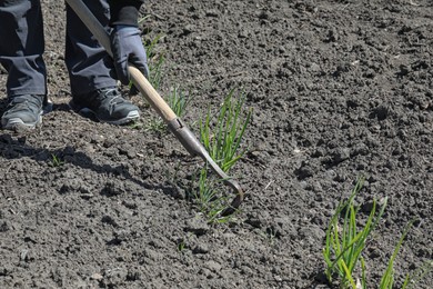 Photo of Gardener shaping soil in garden on sunny day, closeup