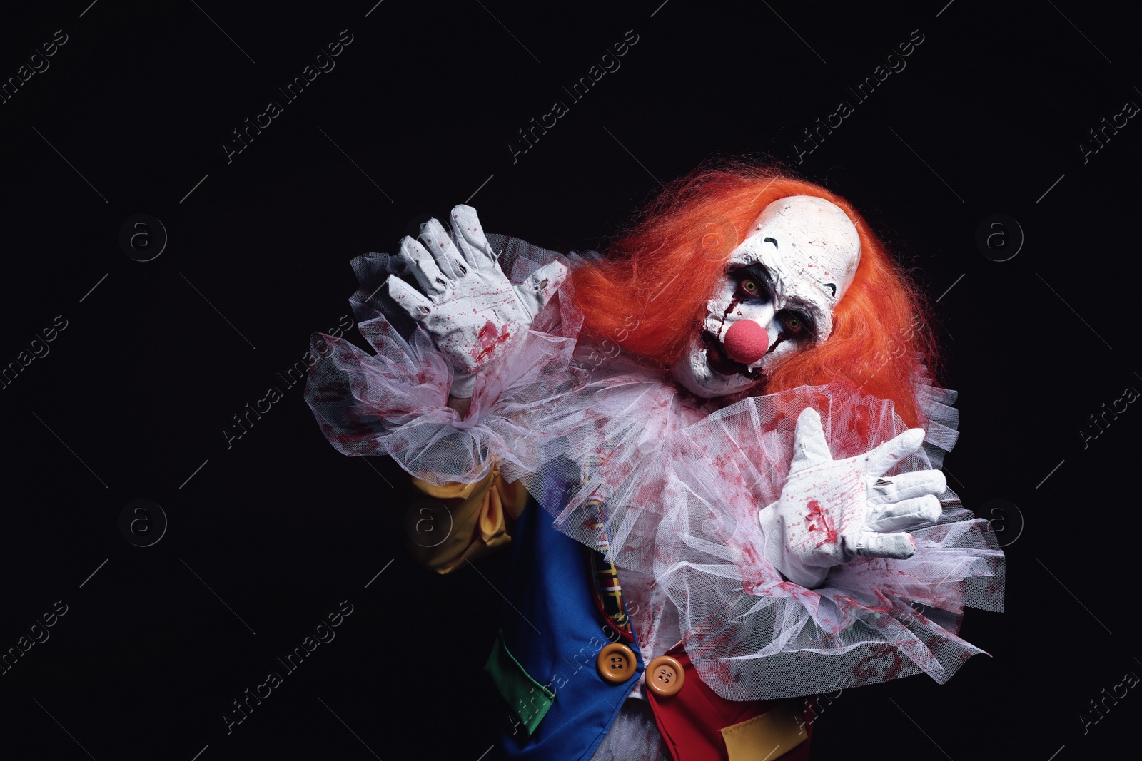 Photo of Terrifying clown on black background, space for text. Halloween party costume