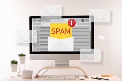 Image of Spam warning message in email software. Envelope illustrations popping out of computer display on office desk