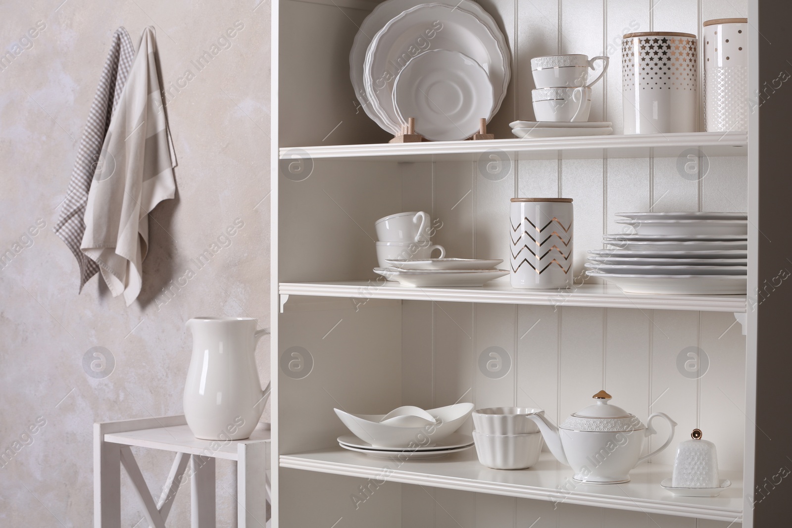 Photo of Stylish storage stand with different ceramic dishware at home