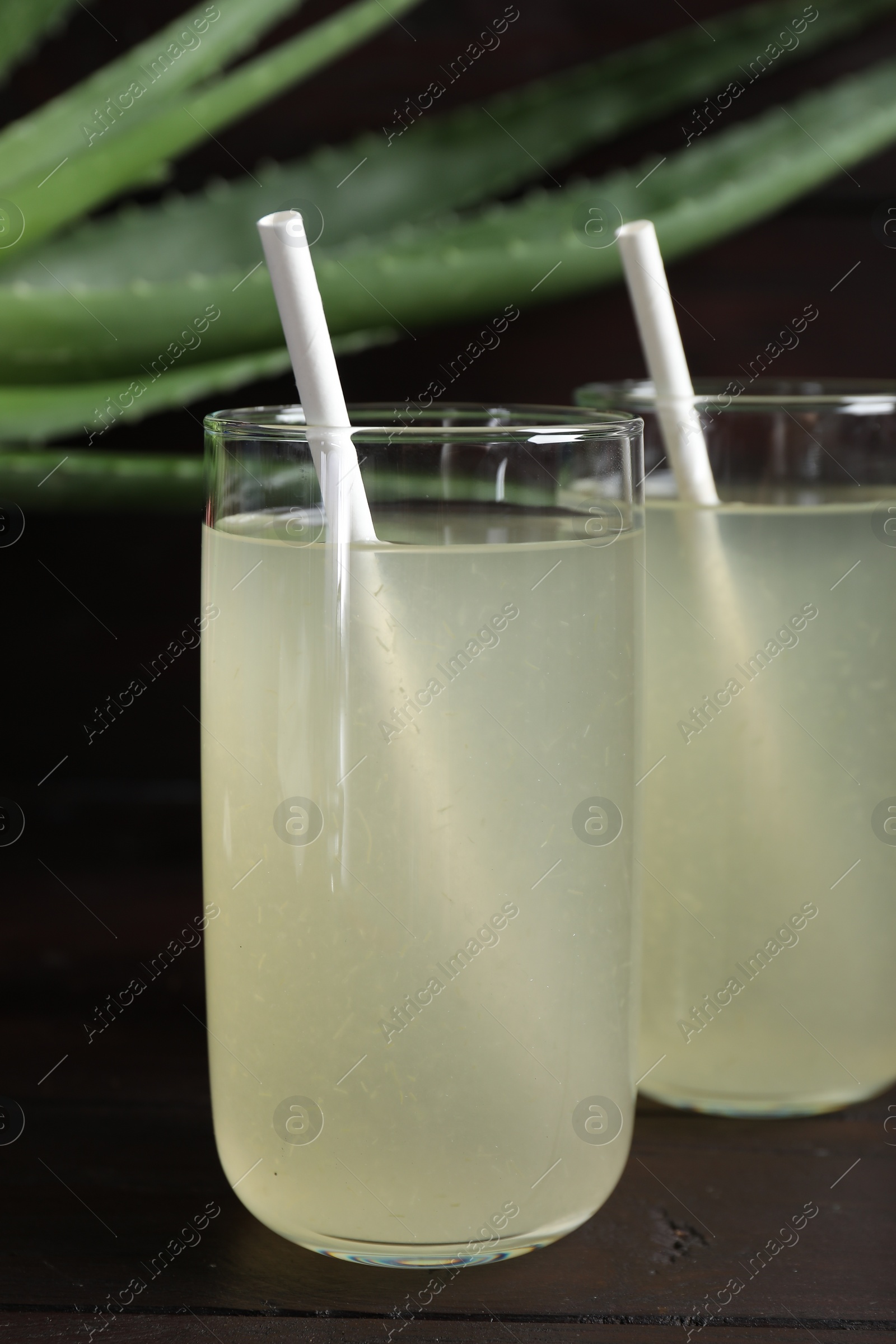 Photo of Tasty aloe juice in glasses on wooden table, closeup