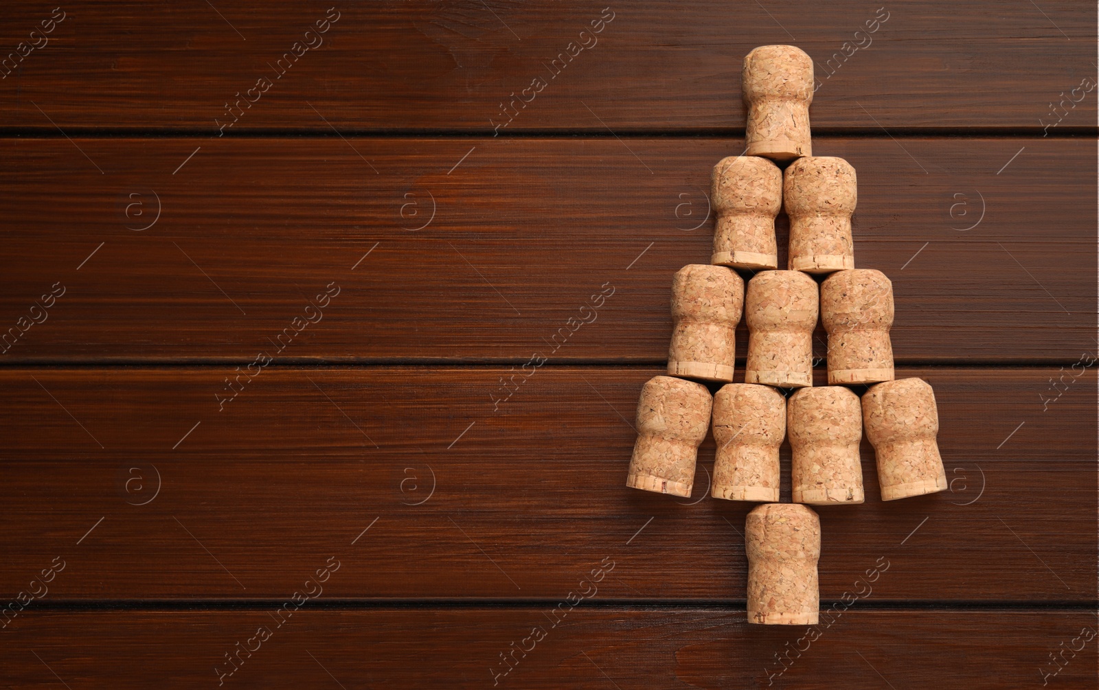 Photo of Christmas tree made of wine corks on wooden table, top view. Space for text