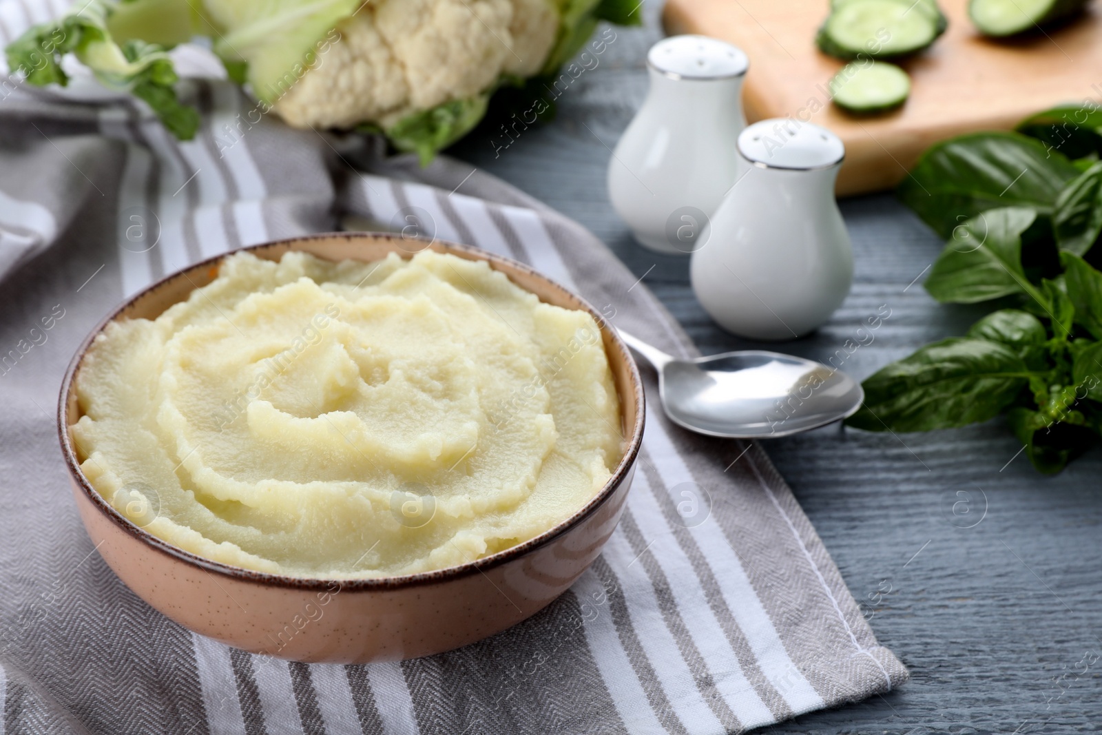 Photo of Bowl with tasty puree and ingredients on light blue wooden table