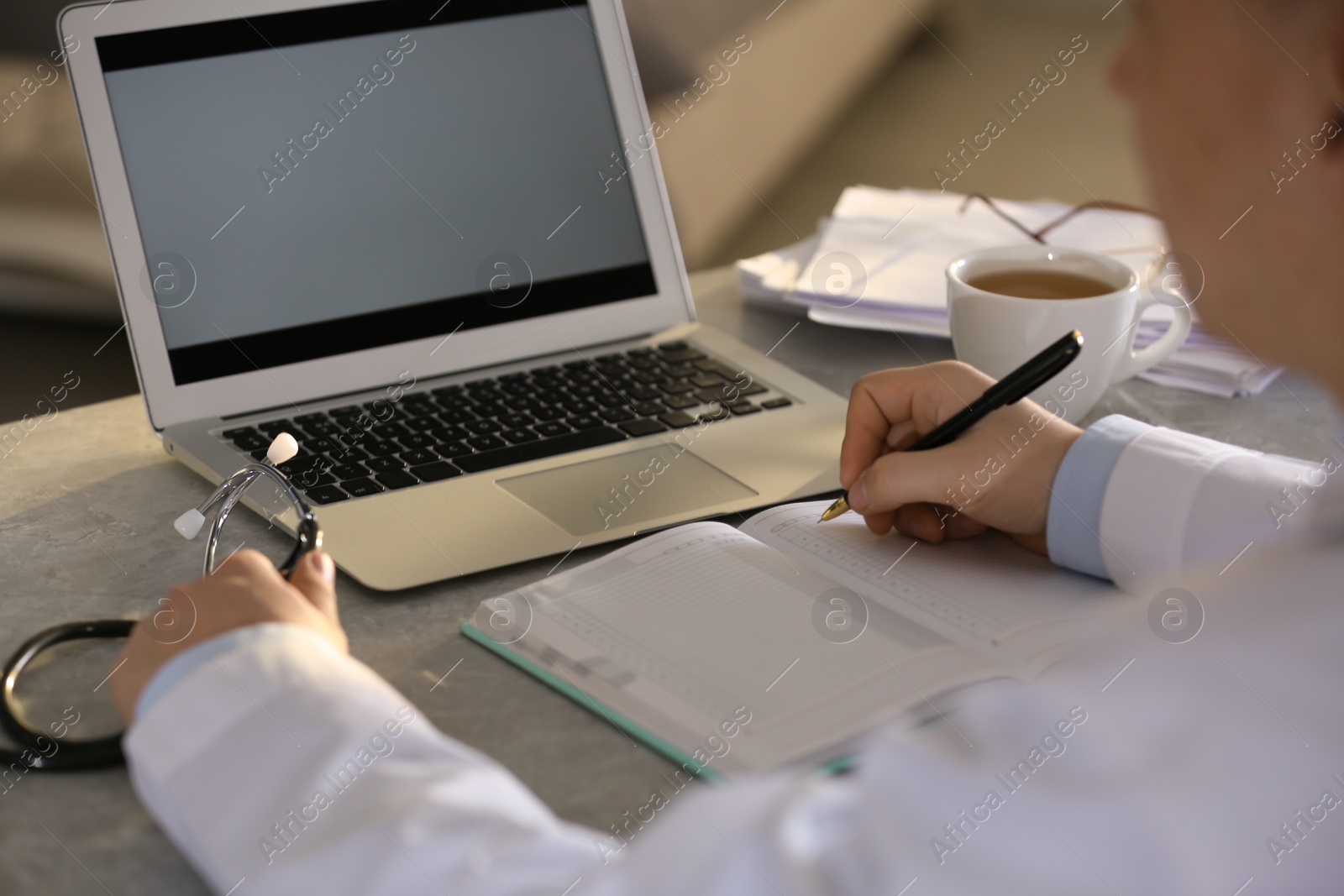 Photo of Professional doctor working at table in office, closeup
