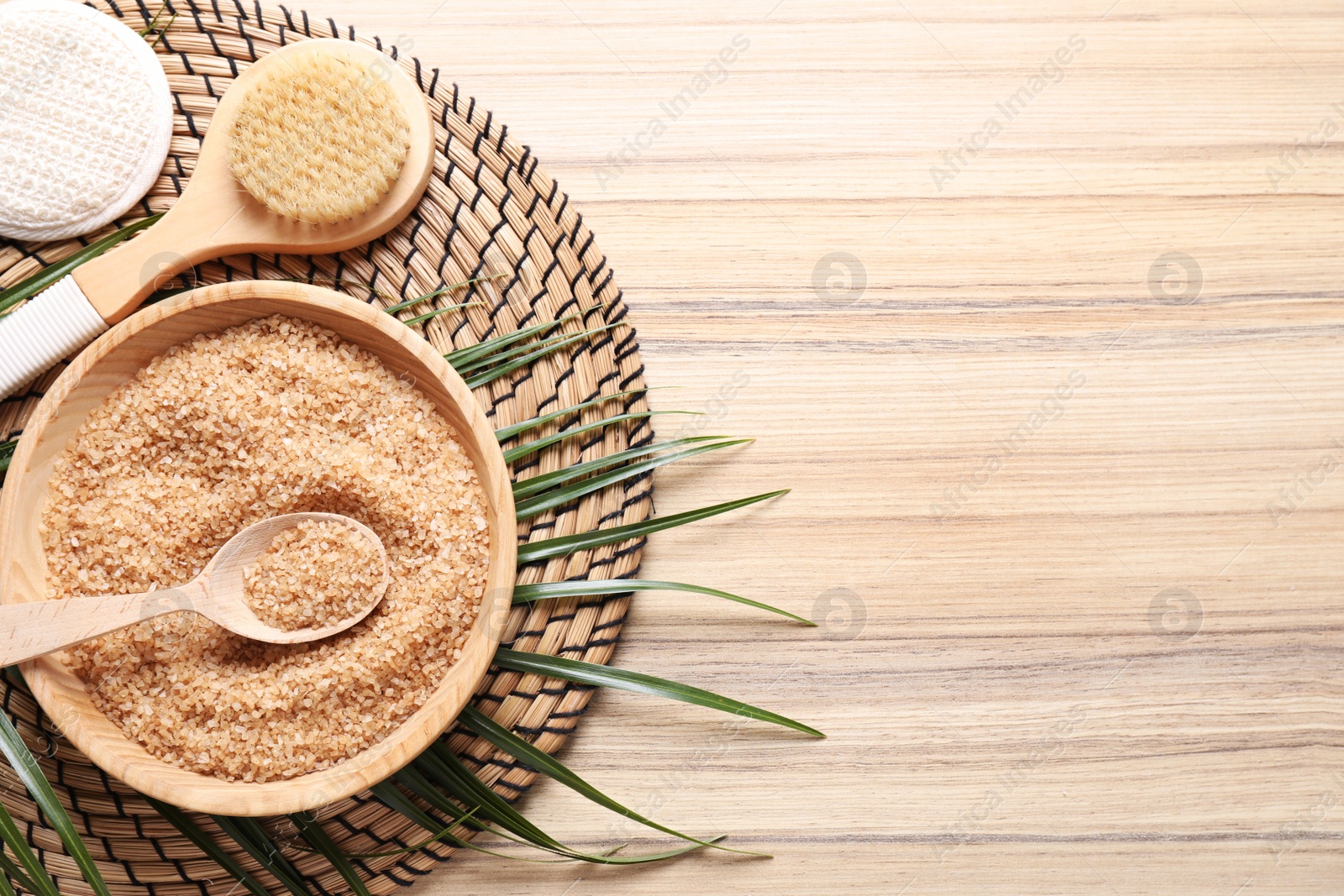 Photo of Salt and supplies for spa scrubbing procedure on wooden background, top view